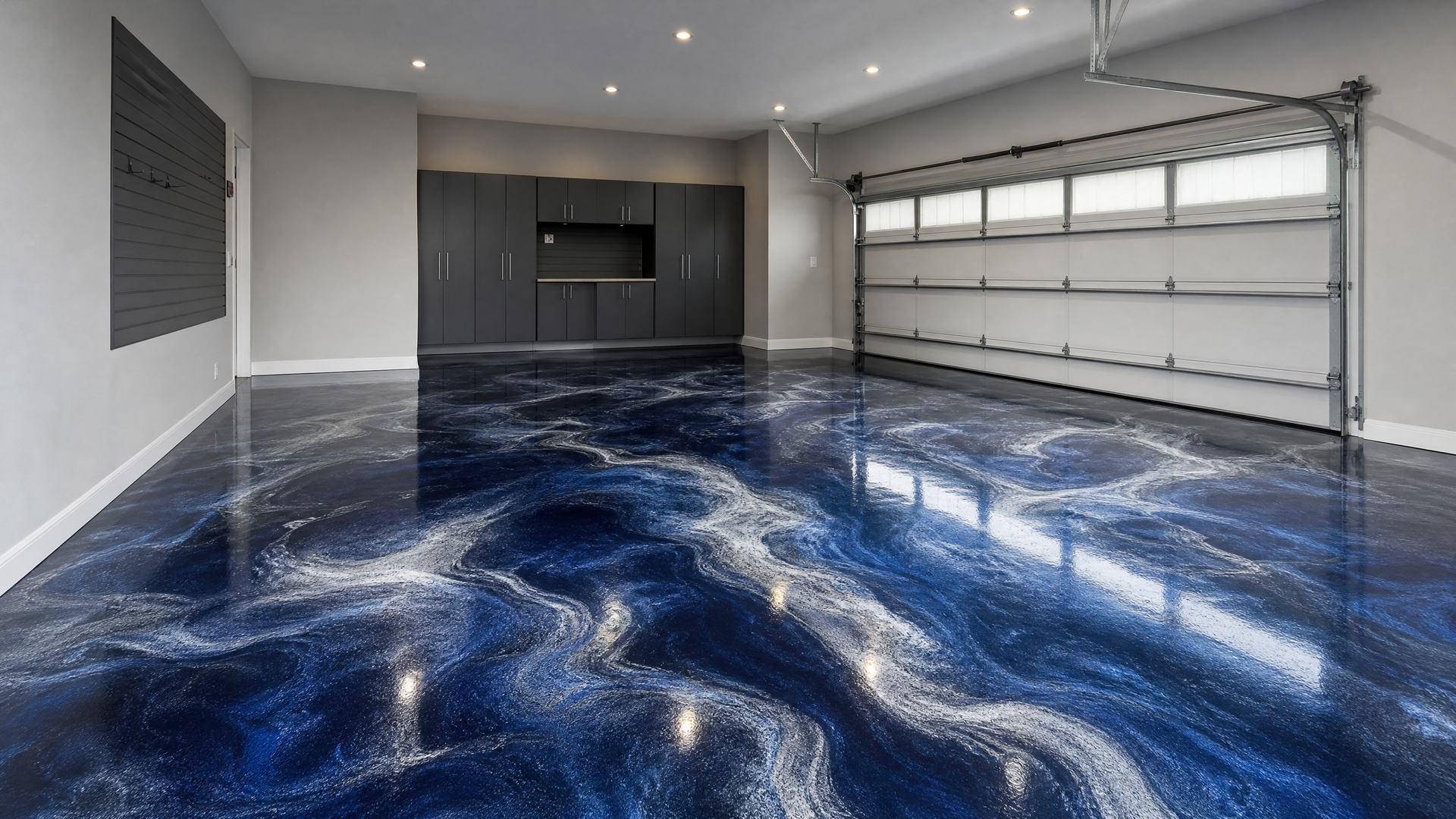 A dark garage with a high-gloss charcoal and copper metallic epoxy floor reflecting the ceiling lights